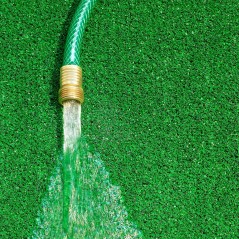 woda lecąca z węża ogrodowego na trawnik